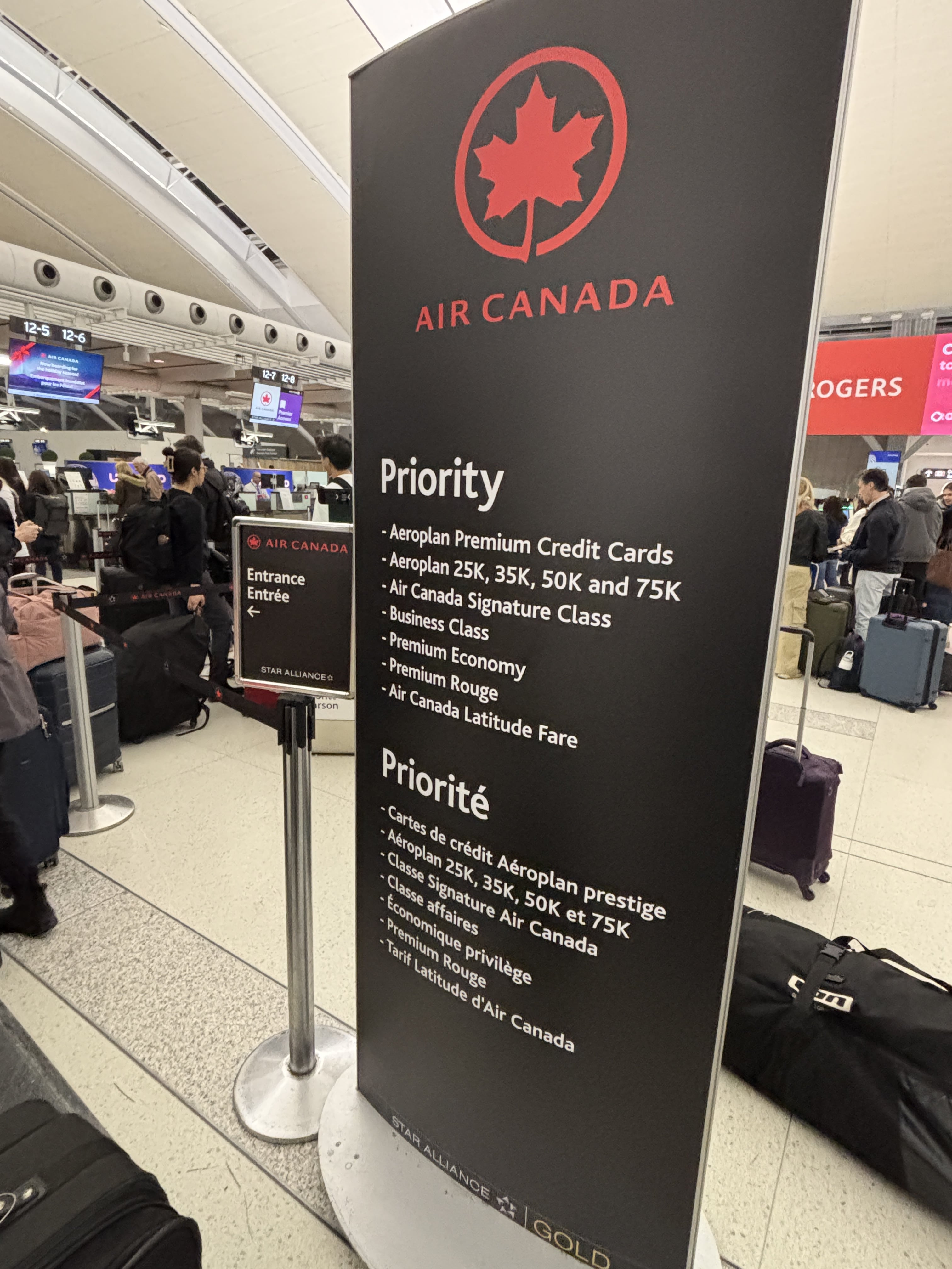 Sign advertising who is eligible to use the Air Canada Priority check-in lane, in English and French.