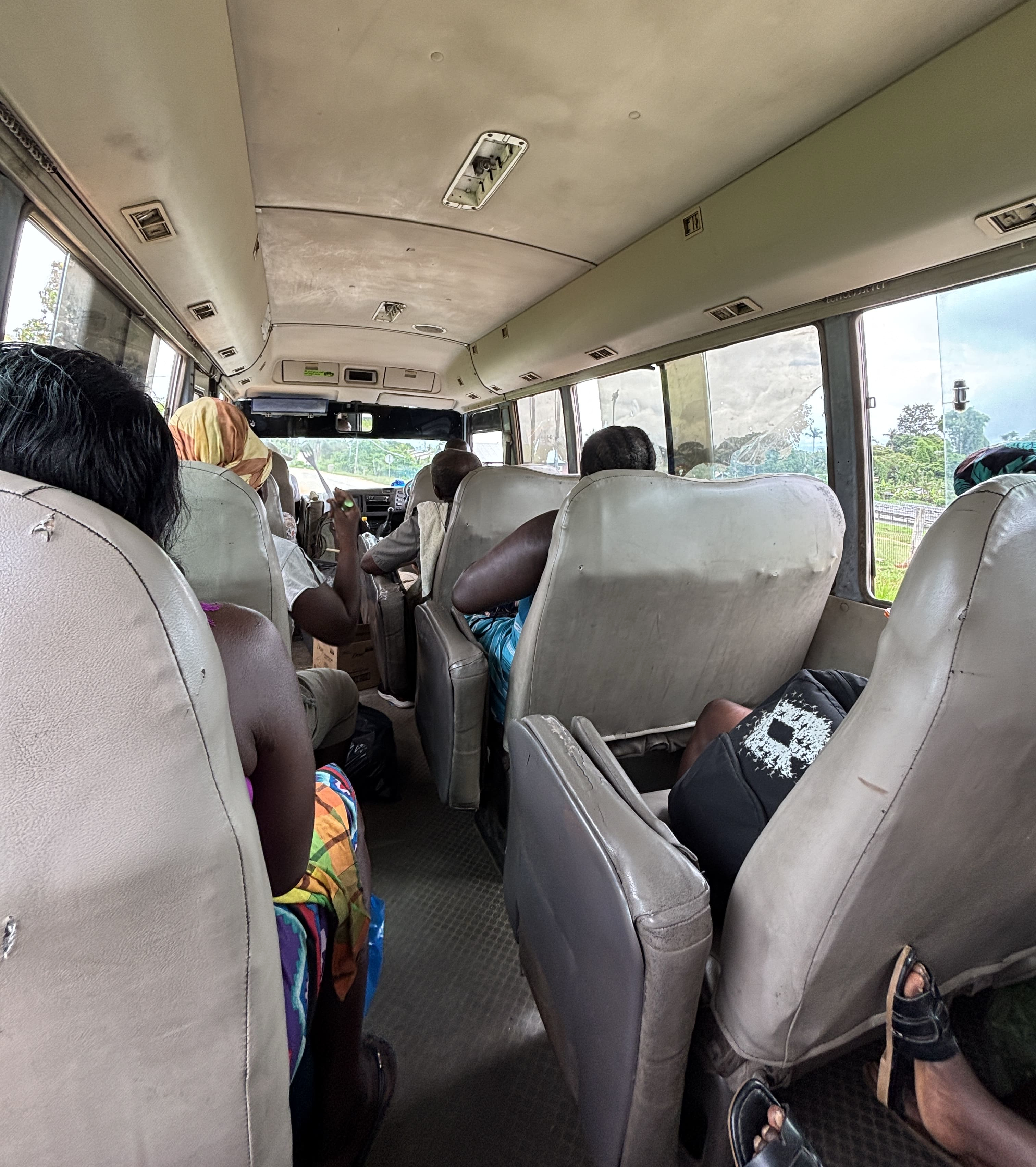 Worn beige seats arranged 1-2 aboard an NVB bus.