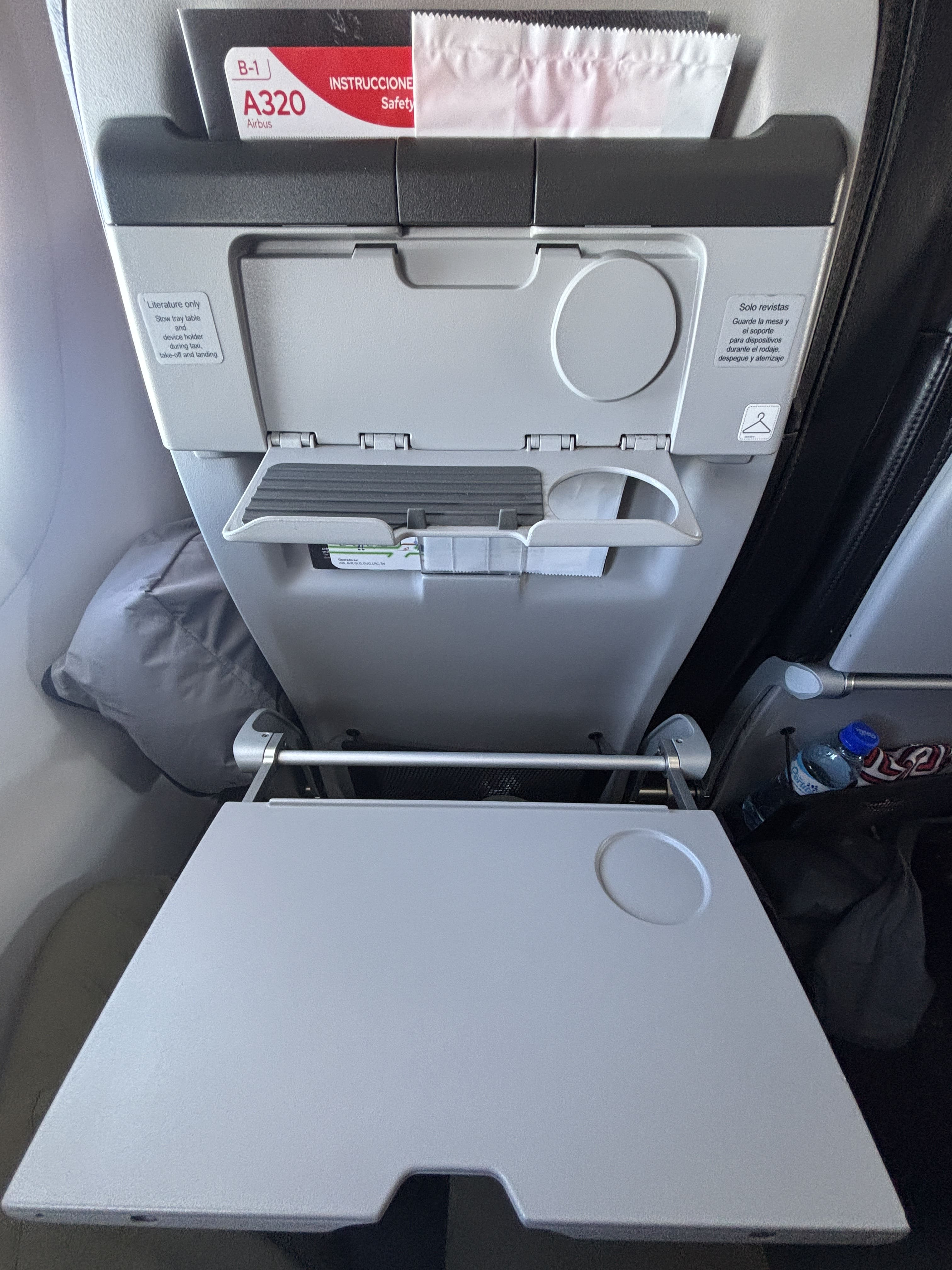 Tray table and device holder that fold down from seats in rows two and three of Avianca business class.