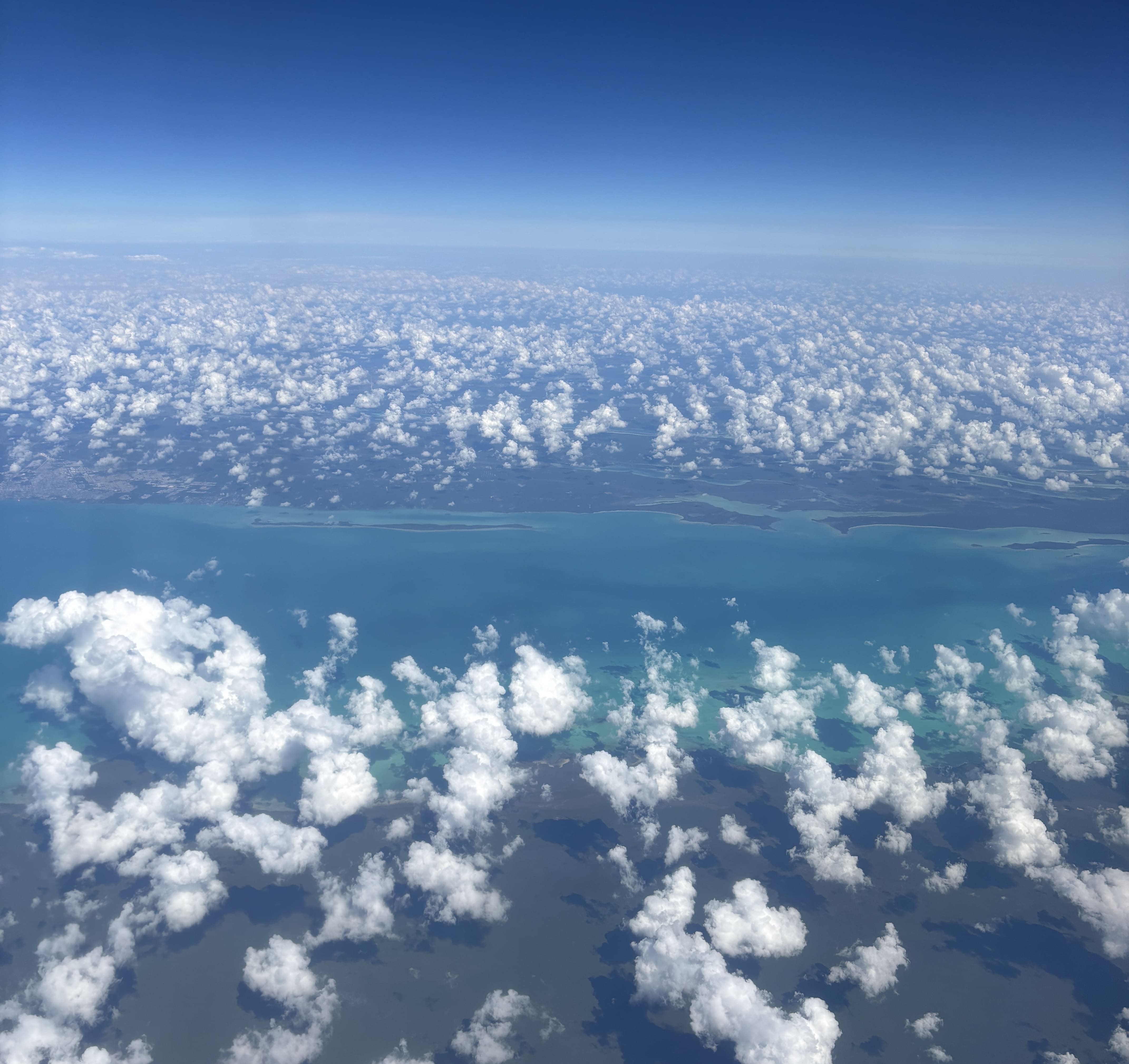 Blue sea and sparse cloud cover somewhere over Mesoamerica.