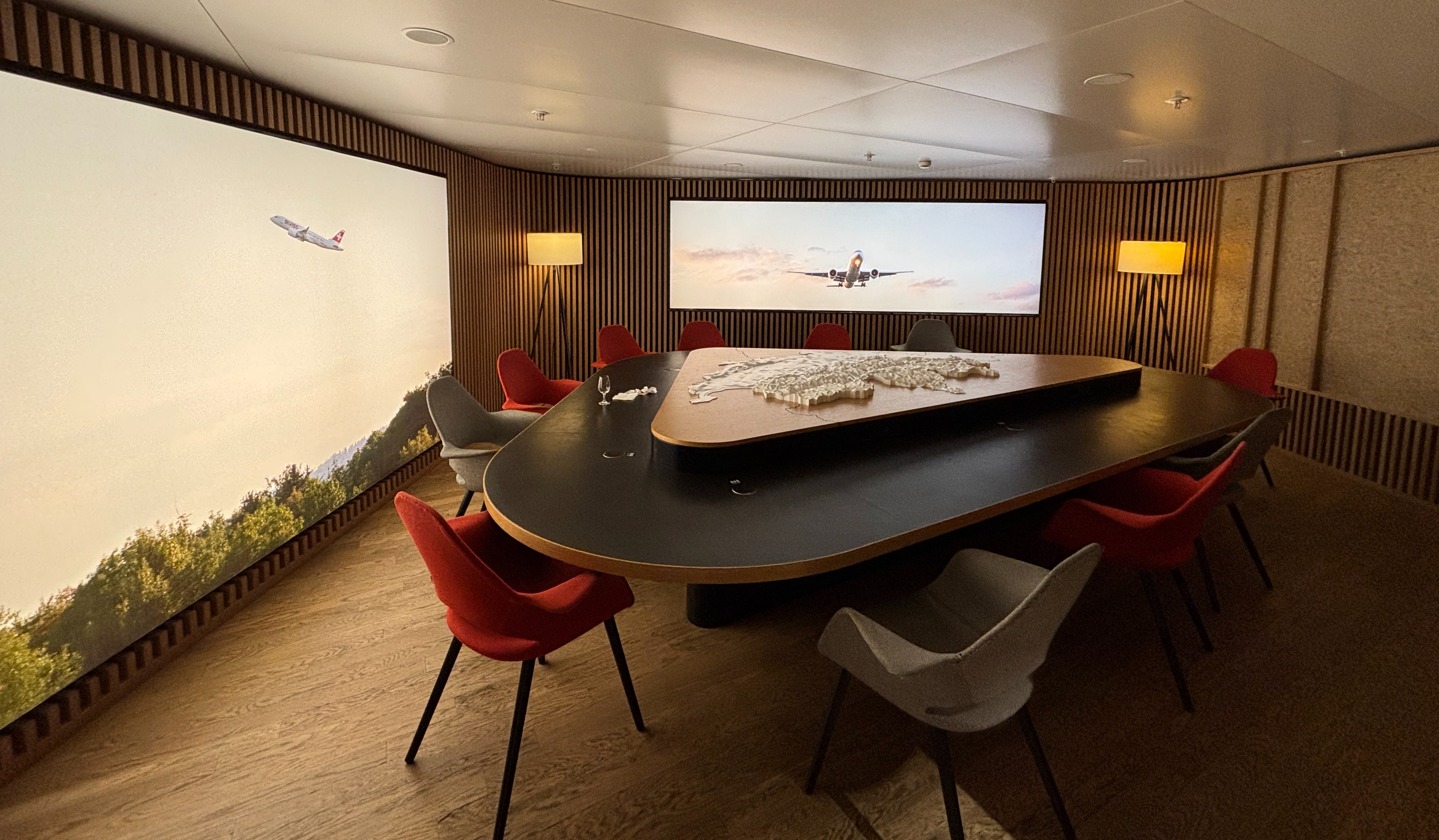 Triangular conference table surrounded by chairs with a topographical display of Switzerland as a centrepiece.
