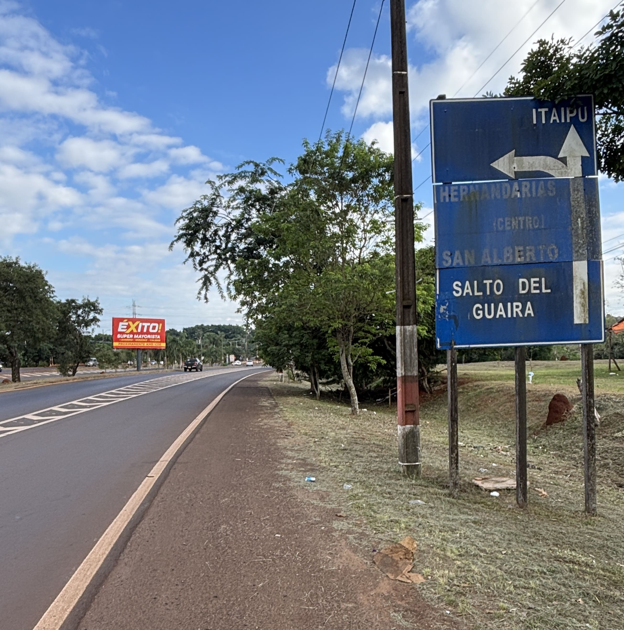 Highway sign showing the entrance to Itaipú straight ahead, and the road to Hernandarias to the left.