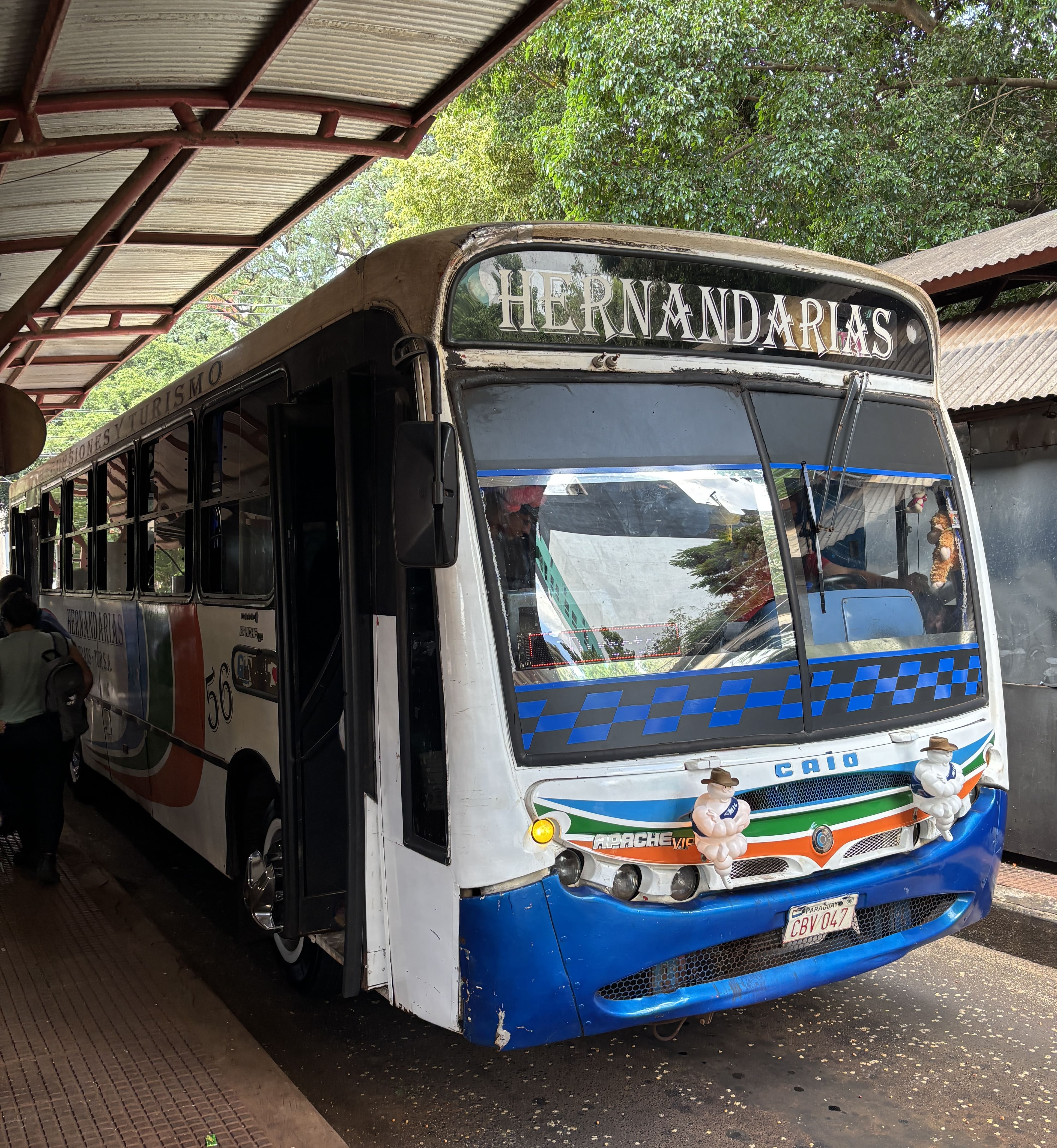 Older-looking blue-and-white bus showing destination Hernandarias.