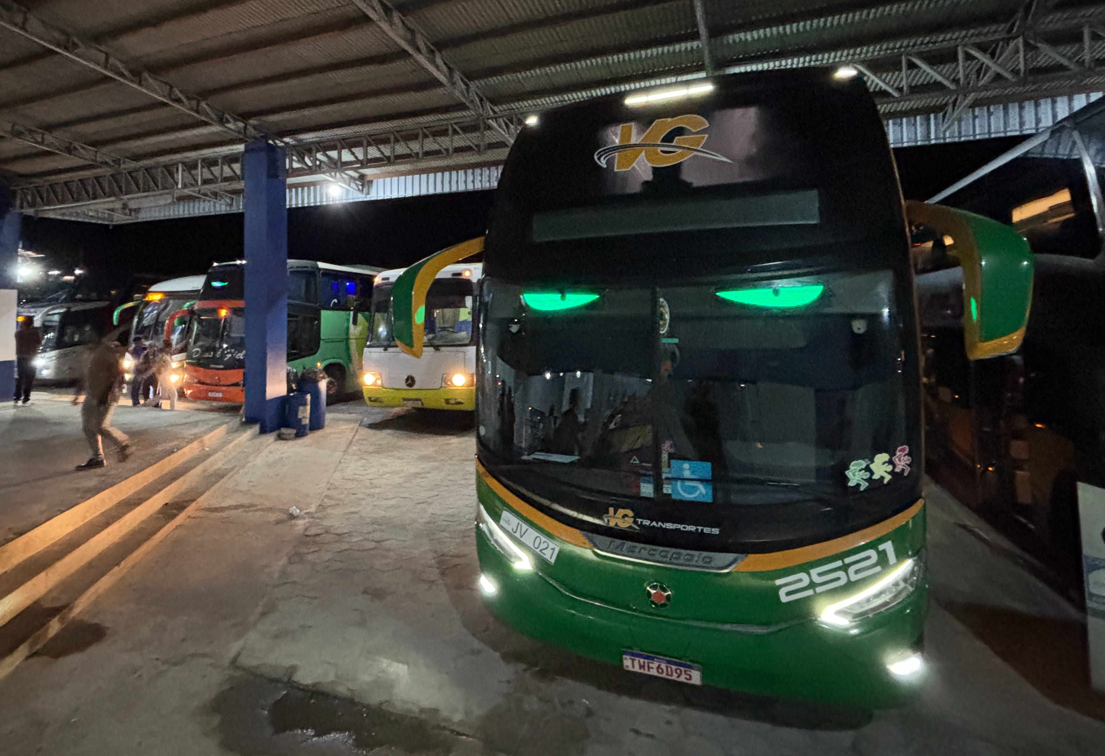 A line of parked busses outside a comfort stop.