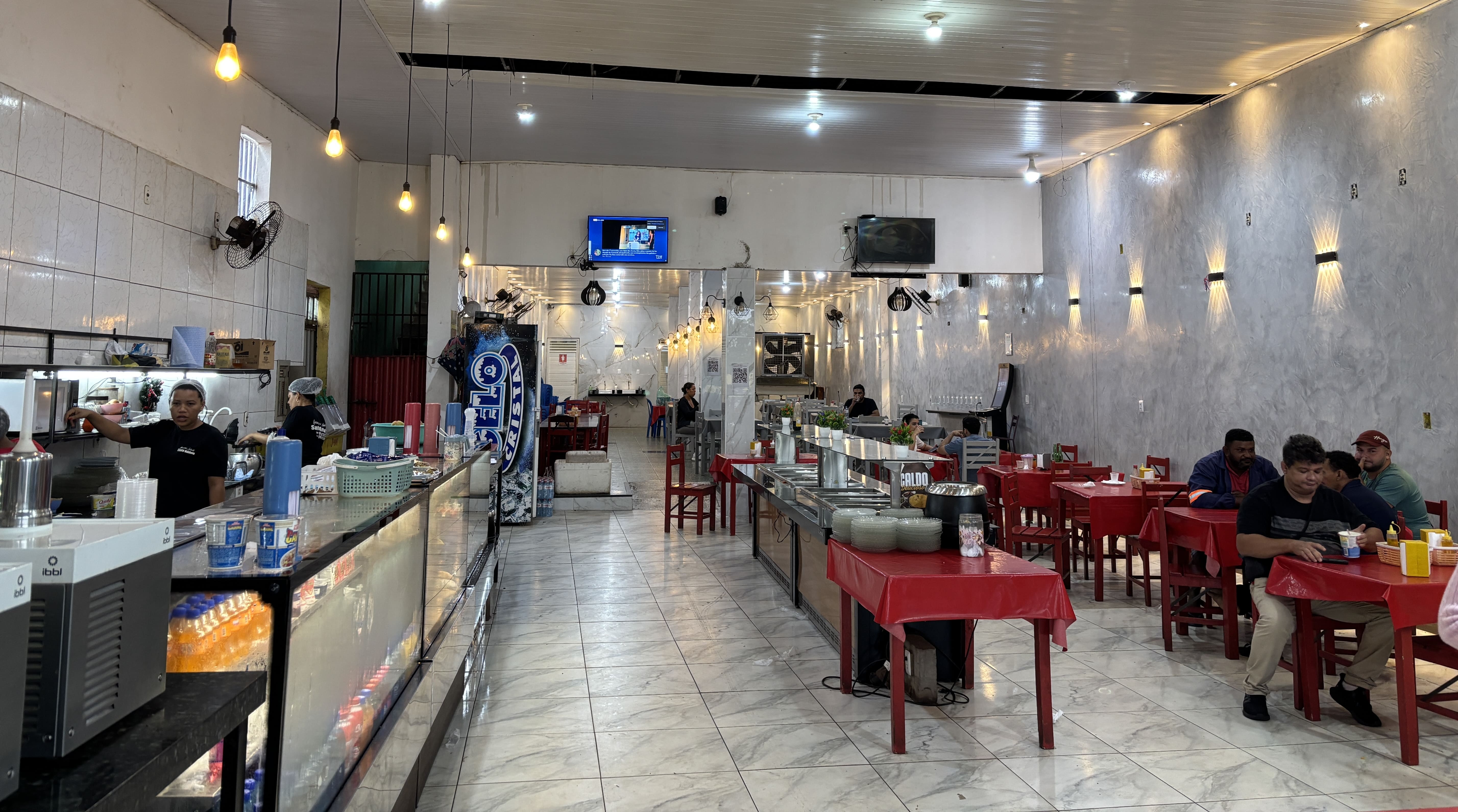 Interior of Churrascaria Santo Antônio showing a food and drink display on the left, and seating area on the right.
