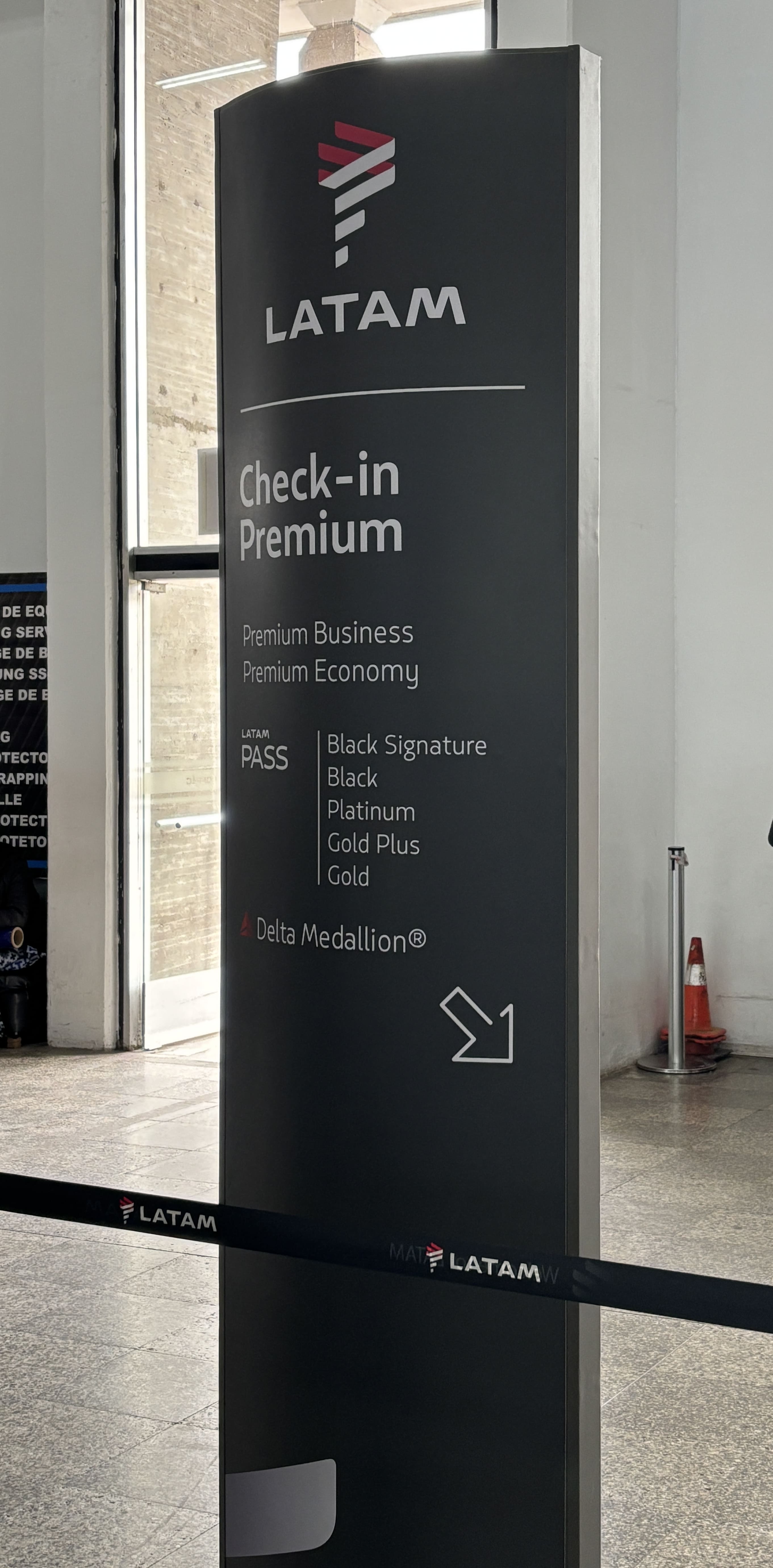 Black sign pointing to the Premium check-in lane for LATAM.