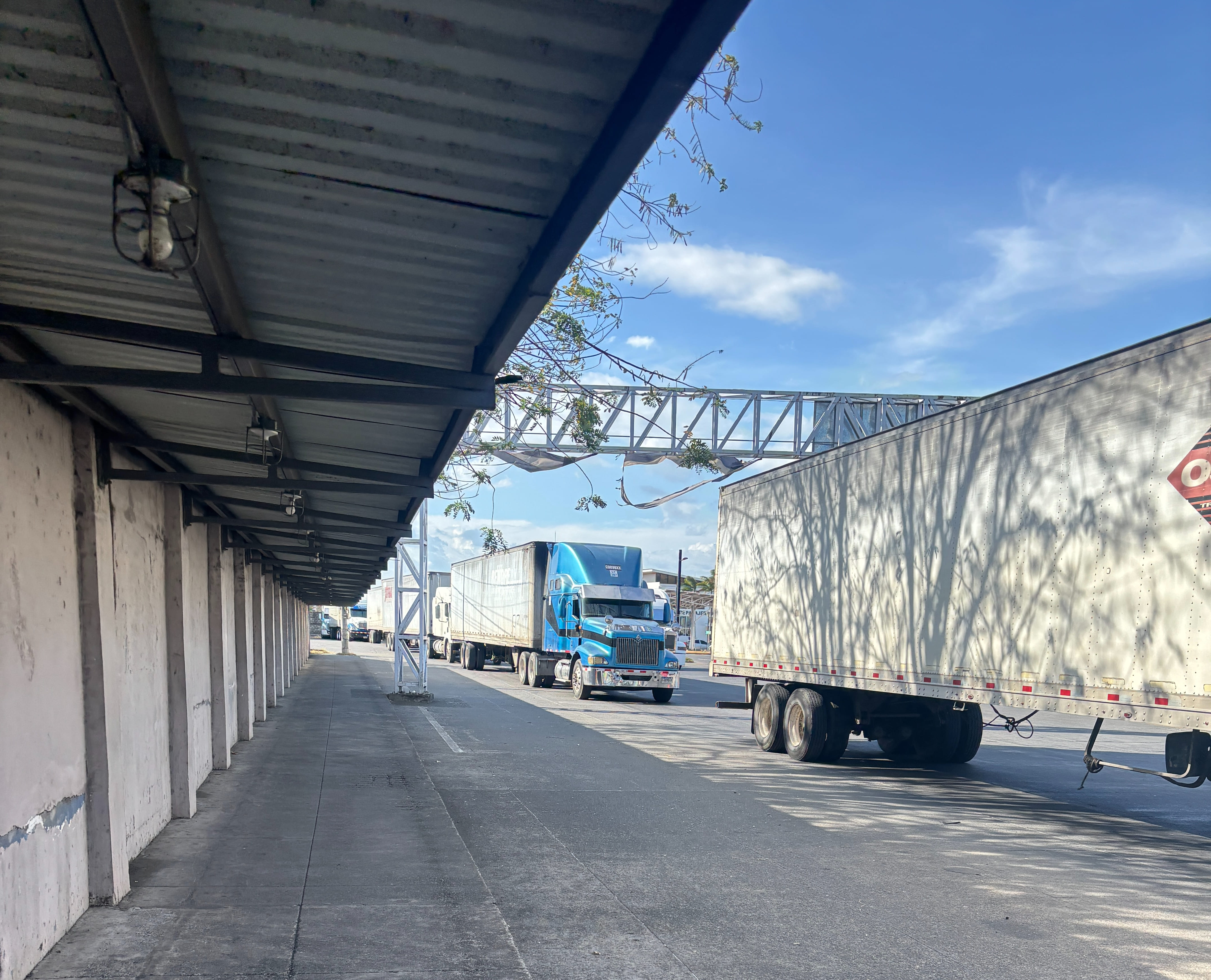 Covered walkway passing transport trucks, leading to Nicaraguan immigration.
