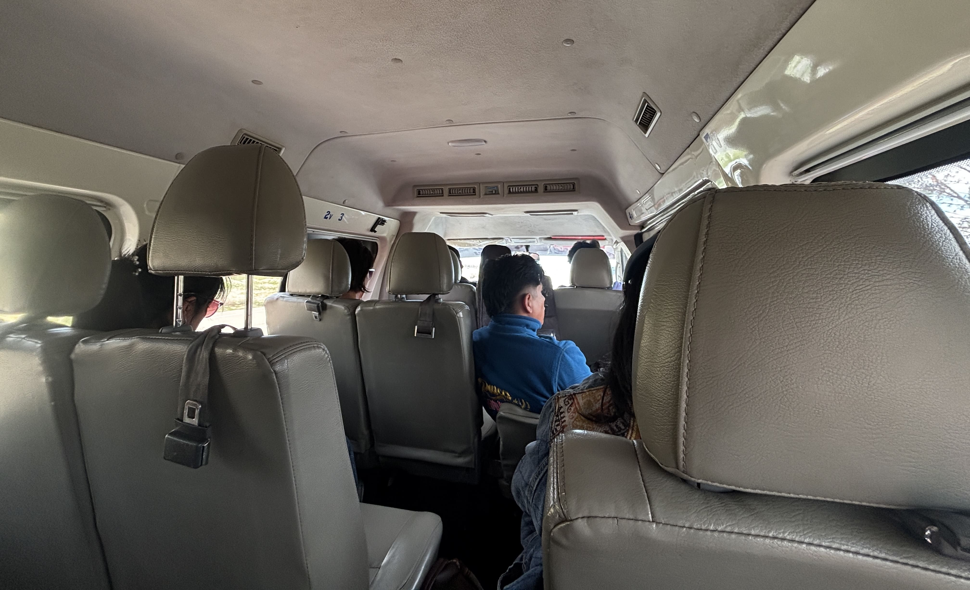 Interior of a King Long passenger van, showing beige seats arranged 2-1.