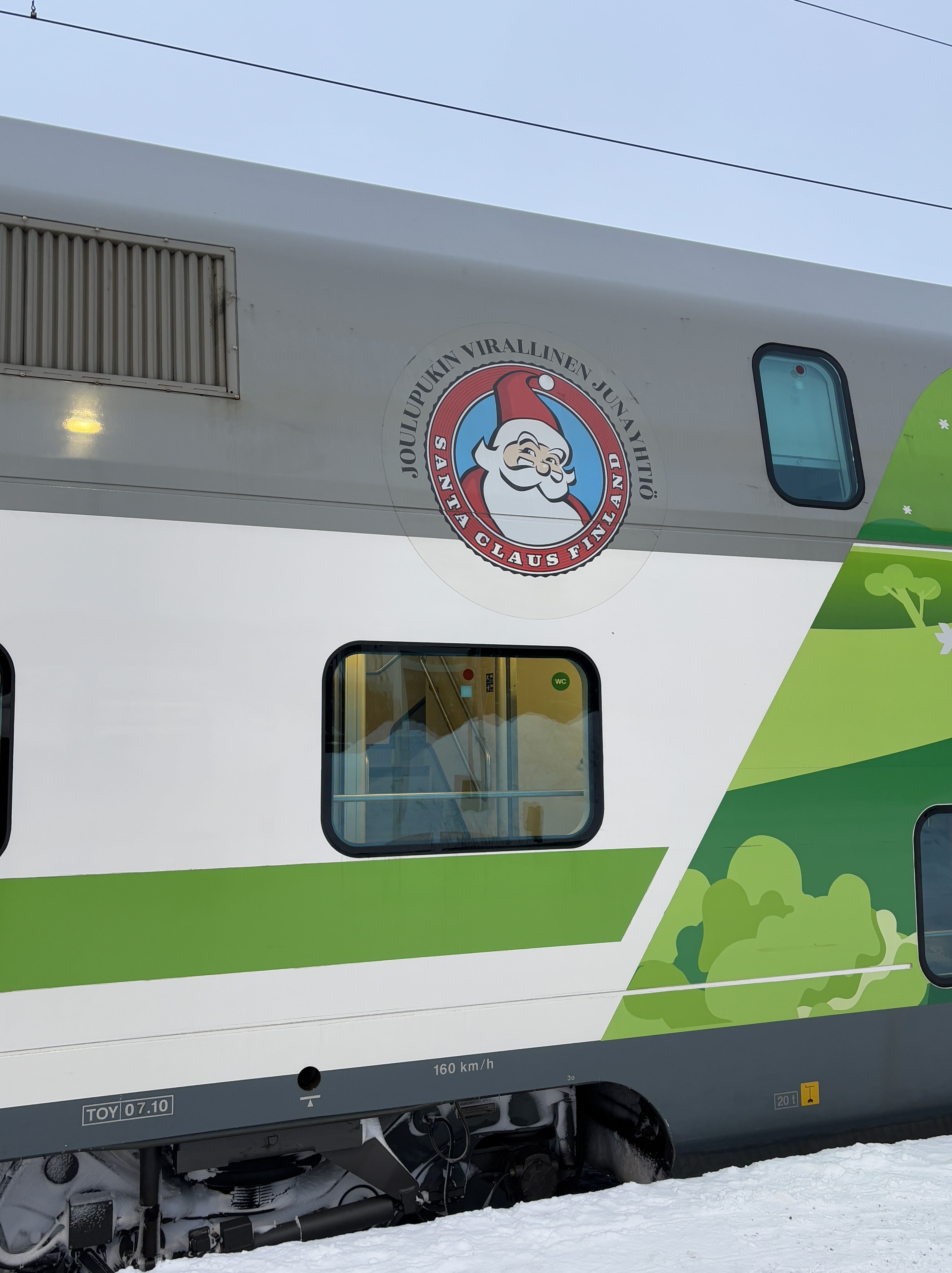 Sticker of Santa Claus affixed to a green, white, and grey VR passenger car.
